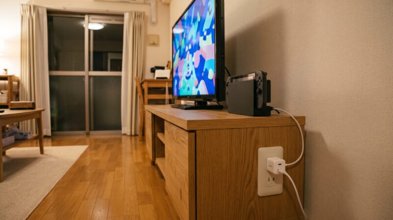 リビングのテレビ横でSwitch2のドックに充電器から給電するイメージ